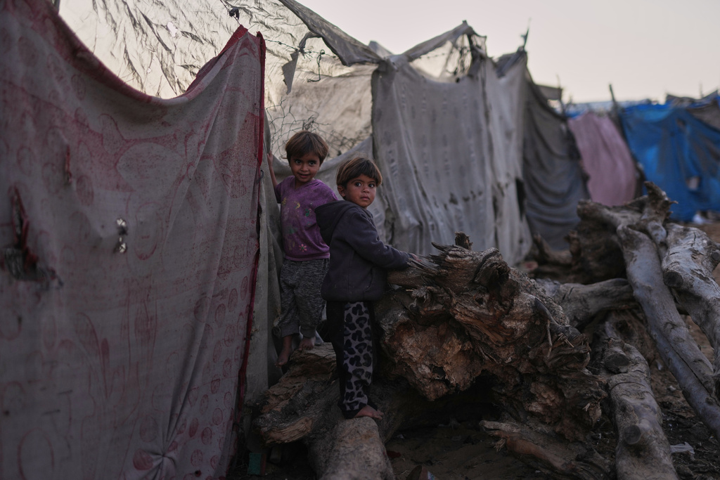 Palestinian children look at the camera as they play in a makeshift camp for displaced people in Zawayda, in the central Gaza Strip, Tuesday, Nov. 18, 2025. (AP Photo/Abdel Kareem Hana)