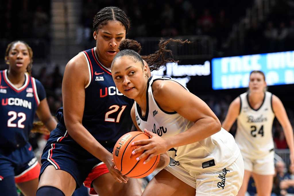 Butler guard Kennedy Langham, front right, looks for help against the defense of UConn forward Sarah Strong (21) during the first half of an NCAA college basketball game in Indianapolis, Sunday, Dec. 28, 2025. (AP Photo/Timothy D. Easley)