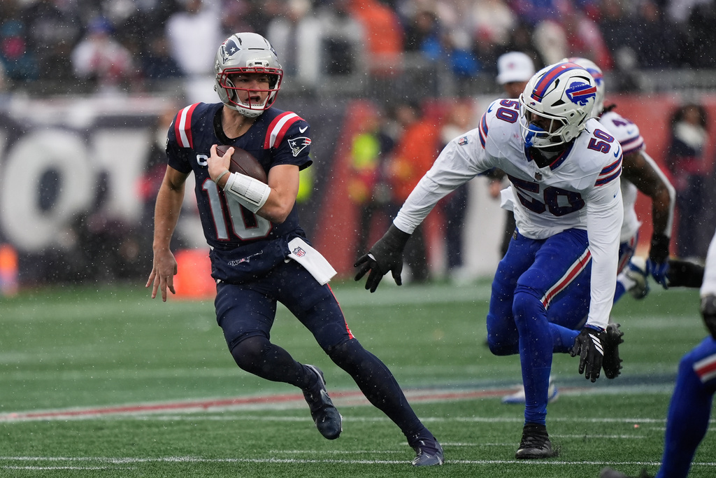 New England Patriots quarterback Drake Maye (10) runs against Buffalo Bills defensive end Greg Rousseau (50) during the first half of an NFL football game in Foxborough, Mass., Sunday, Dec. 14, 2025. (AP Photo/Robert F. Bukaty)