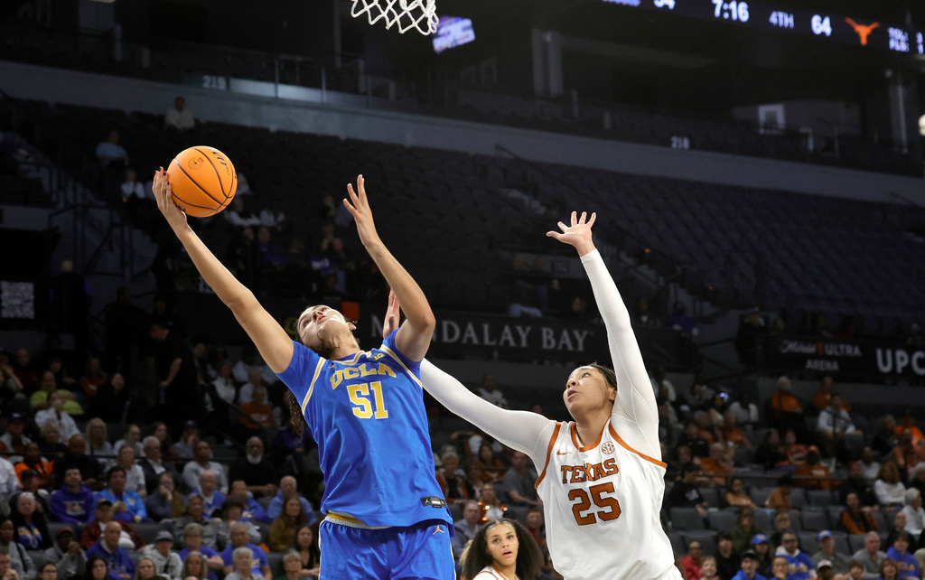 UCLA center Lauren Betts (51) catches a pass in front of Texas forward Breya Cunningham (25) during the second half of an NCAA college basketball game in the Players Era tournament, Wednesday, Nov. 26, 2025, in Las Vegas. (AP Photo/Steve Marcus)