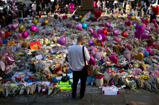 FILE - A man stands next to flowers for the victims of a bombing at St. Ann's Square in central Manchester, England, May 26, 2017. (AP Photo/Emilio Morenatti, File) FILE - A man stands next to flowers for the victims of a bombing at St. Ann's Square in central Manchester, England, May 26, 2017. (AP Photo/Emilio Morenatti, File)