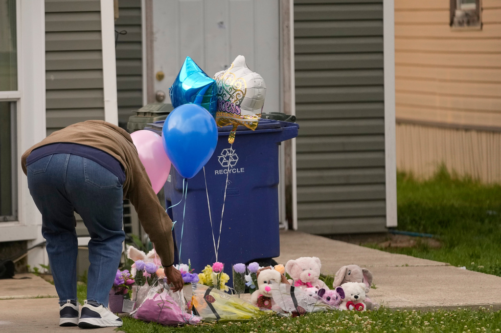 A person leaves a gift at a makeshift memorial on the front lawn of the home where children were killed during a mass shooting the day before in Shreveport, La., Monday, April 20, 2026. (AP Photo/Gerald Herbert)