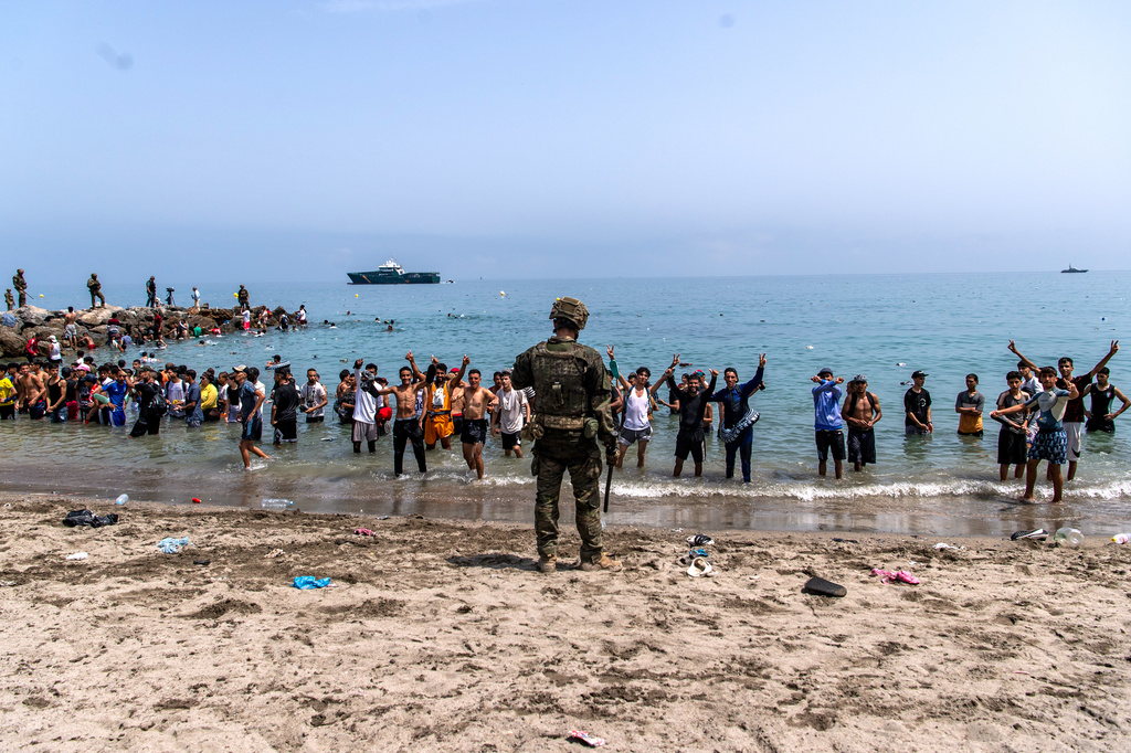 Spanish army soldiers block access to the beach for people crossing from Morocco into the Spanish enclave of Ceuta, Friday, July 31, 2026. (AP Photo/Antonio Sempere)