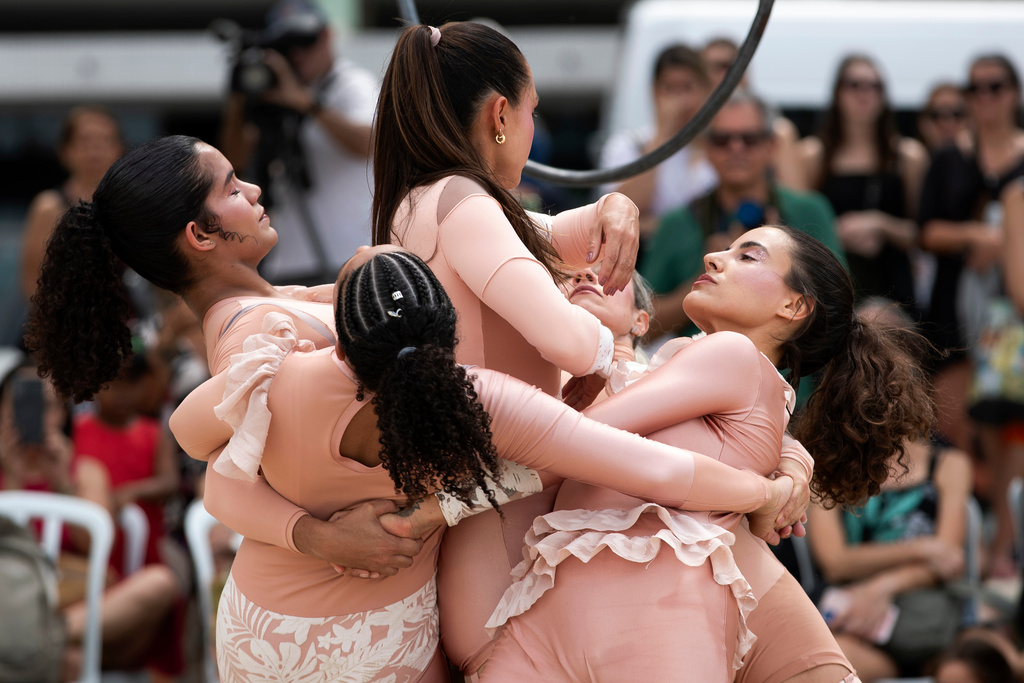 Members of the group aerial circus "Pendurados” perform in an open-air show that explores healing from sexual violence through art and community, at Icarai Beach in Niteroi, Rio de Janeiro state, Brazil, Saturday, Oct. 18, 2025. (AP Photo/Bruna Prado)