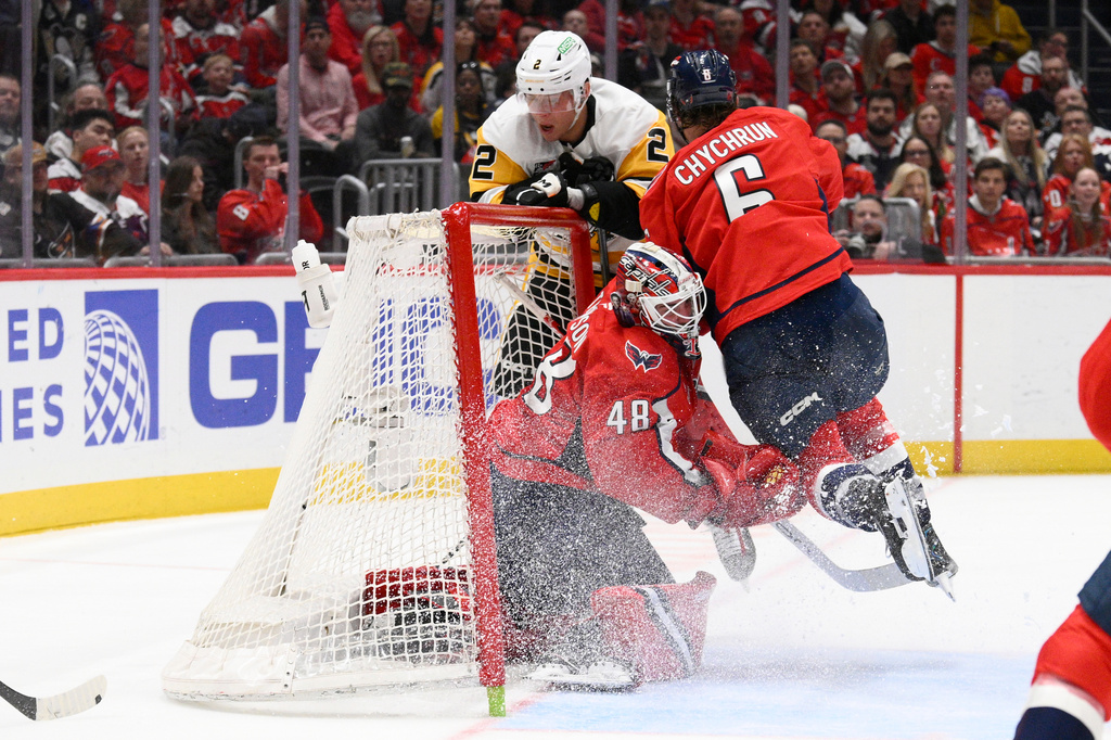 Washington Capitals defenseman Jakob Chychrun (6) collides into the net and his goalie Logan Thompson (48) and Pittsburgh Penguins right wing Rutger McGroarty (2) during the second period of an NHL hockey game, Sunday, April 12, 2026, in Washington. (AP Photo/Nick Wass)