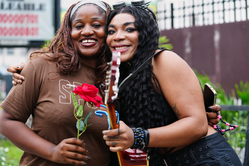 Nigerian rock musician Bianca “Clayrocksu” Okorocha, right, poses for a photograph with Barbara Lulu, a Lagos resident, left, after handing her a single-stem rose ahead of Valentine's Day in Lagos, Nigeria, Tuesday, Feb.10, 2026. (AP Photo/Sunday Alamba)