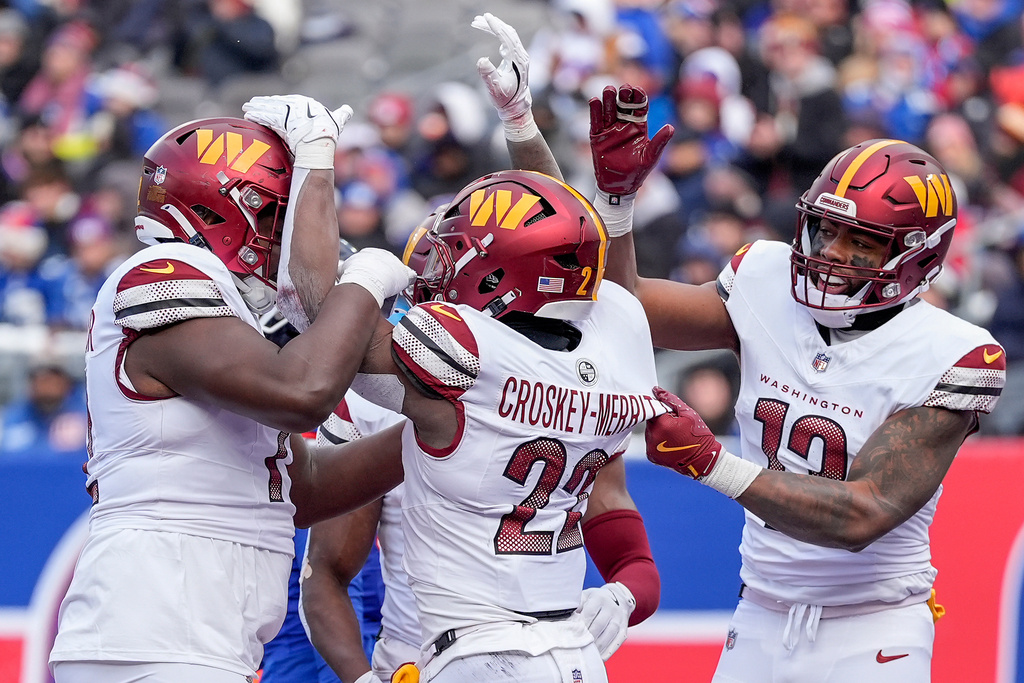 Washington Commanders running back Jacory Croskey-Merritt (22) celebrates with teammates after scoring a touchdown against the New York Giants during the second quarter of an NFL football game, Sunday, Dec. 14, 2025, in East Rutherford, N.J. (AP Photo/Yuki Iwamura)