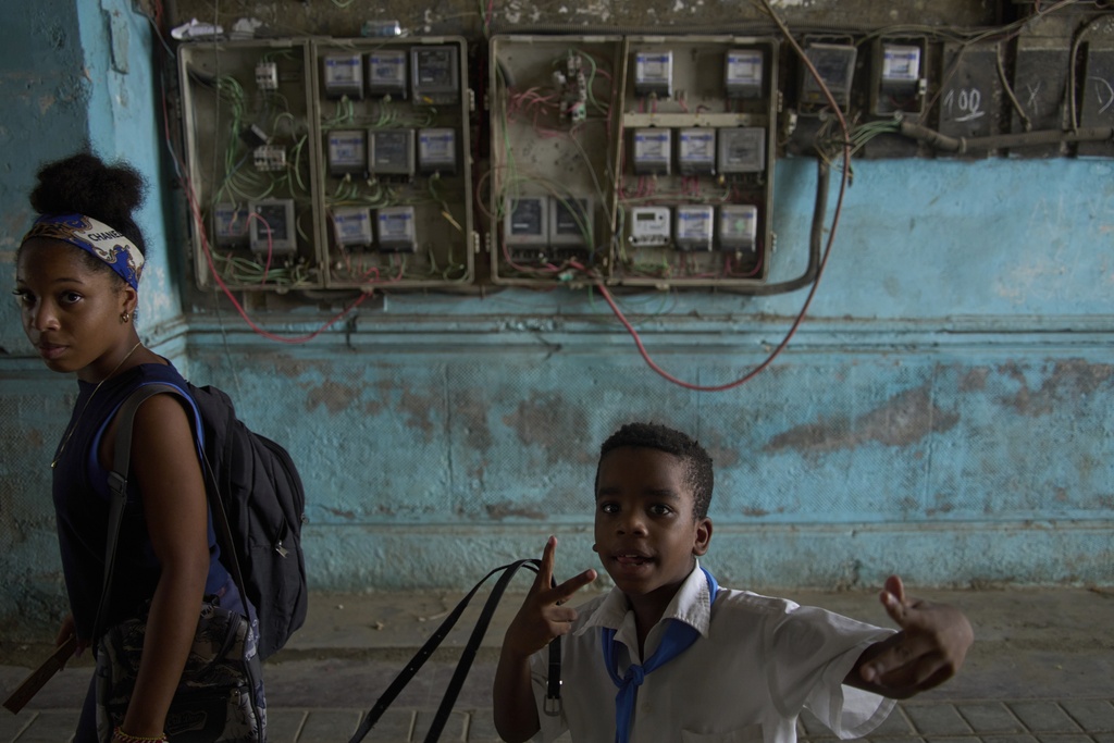 A youth stops to strike a pose in an apartment building where the electricity meters cover the wall during a blackout in Havana, Wednesday, Sept. 10, 2025. (AP Photo/Ramon Espinosa)