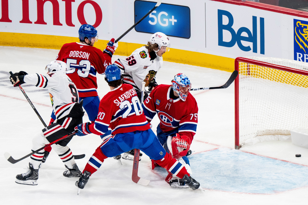 Chicago Blackhawks' Frank Nazar (91) scores against Montreal Canadiens goaltender Jakub Dobes (75) while Canadiens' Juraj Slafkovsky (20), Canadiens' Noah Dobson (53) and Blackhawks' Tyler Bertuzzi (59) stand by during first-period NHL hockey game action in Montreal, Thursday, Dec. 18, 2025. (Christopher Katsarov/The Canadian Press via AP)
