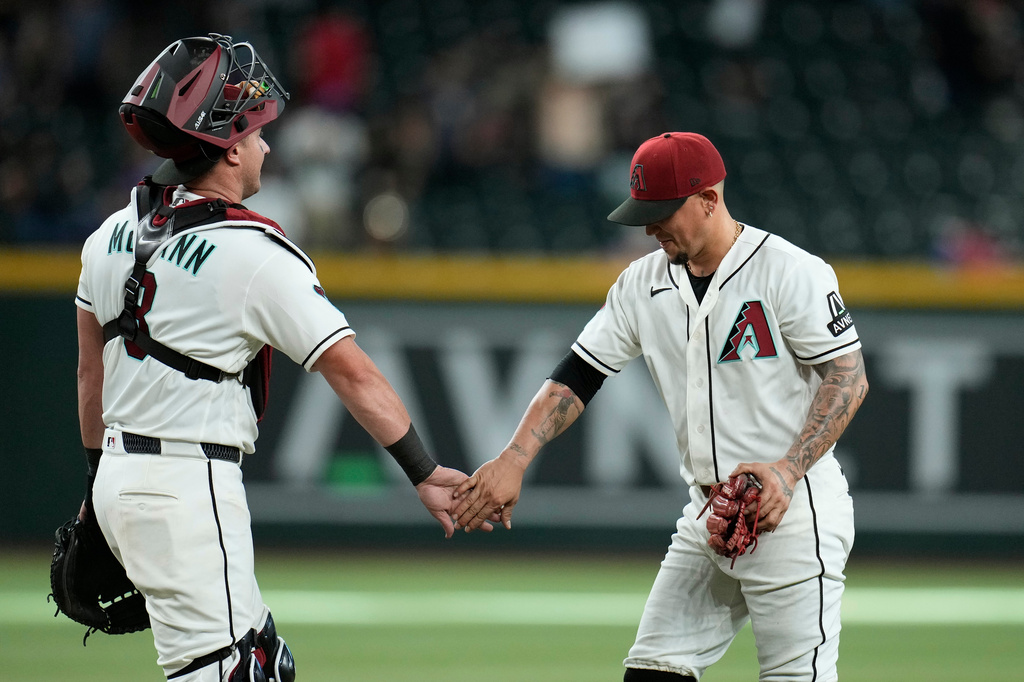 Arizona Diamondbacks pitcher Ildemaro Vargas, right, slaps hands with Arizona Diamondbacks catcher James McCann after a baseball game against the Athletics, Wednesday, July 22, 2026, in Phoenix. (AP Photo/Ross D. Franklin)