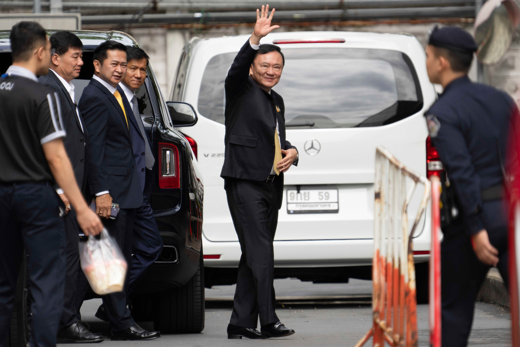 Former Thai Prime Minister Thaksin Shinawatra, center, arrives at Criminal Court for a verdict for allegedly defaming the monarchy in Bangkok, Thailand, Friday, Aug. 22, 2025. (AP Photo/Arnun Chonmahatrakool)