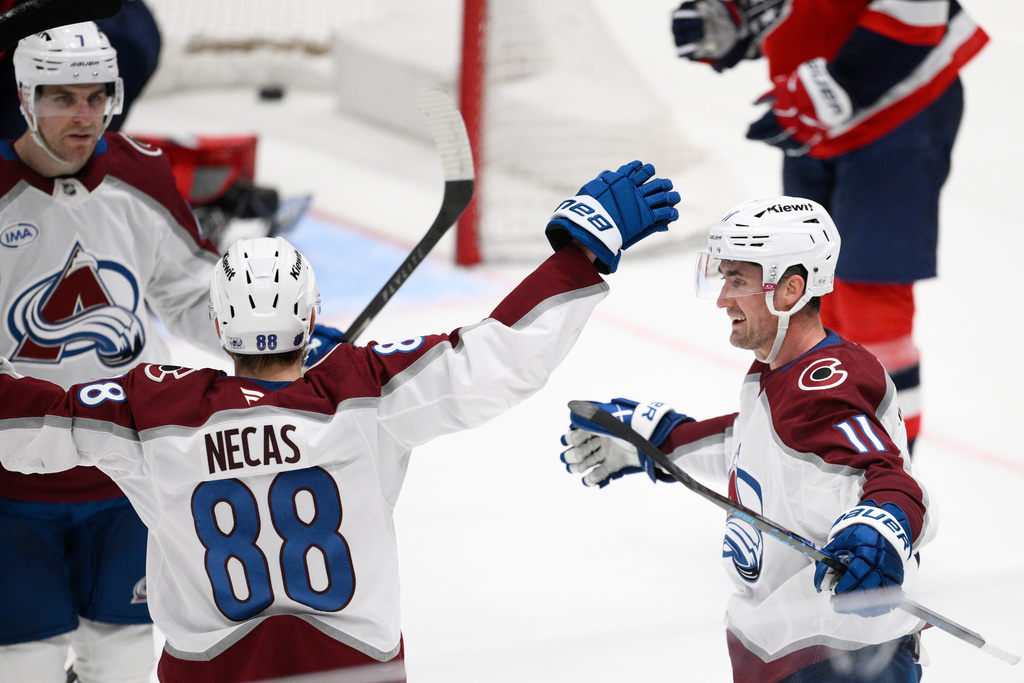 Colorado Avalanche center Brock Nelson (11) celebrates after his winning goal with center Martin Necas (88) and others during overtime of an NHL hockey game against the Washington Capitals, Sunday, March 22, 2026, in Washington. (AP Photo/Nick Wass)
