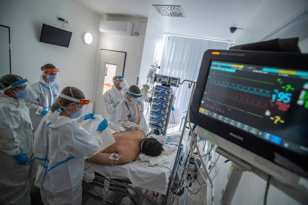 FILE - Doctors and nurses wearing protective gears attend a patient on ventilator at the intensive care unit of Szent Laszlo Hospital treating COVID-19 patients during the pandemic of new coronavirus COVID-19 in Budapest, Hungary, on Dec. 13, 2021. (Zoltan Balogh/MTI via AP, File)