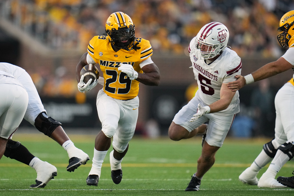 Missouri running back Ahmad Hardy (29) runs with the ball as Massachusetts linebacker Tyler Martin (5) defends during the first half of an NCAA college football game Saturday, Sept. 27, 2025, in Columbia, Mo. (AP Photo/Jeff Roberson)