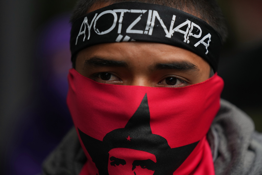 A demonstrator marches to mark the 11th anniversary of the disappearance of 43 students from an Ayotzinapa Rural Teachers' College, in Mexico City, Friday, Sept. 26, 2025. (AP Photo/Fernando Llano)