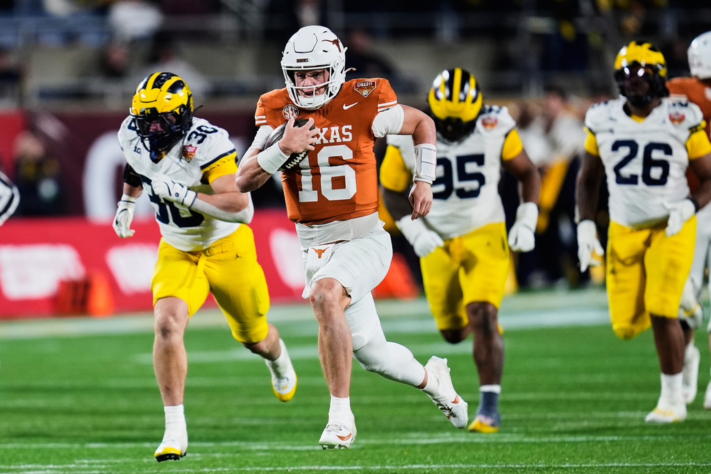 Texas quarterback Arch Manning (16) outruns the Michigan defense on his way to a 60-yard touchdown run during the second half of the Citrus Bowl NCAA college football game, Wednesday, Dec. 31, 2025, in Orlando, Fla. (AP Photo/John Raoux)