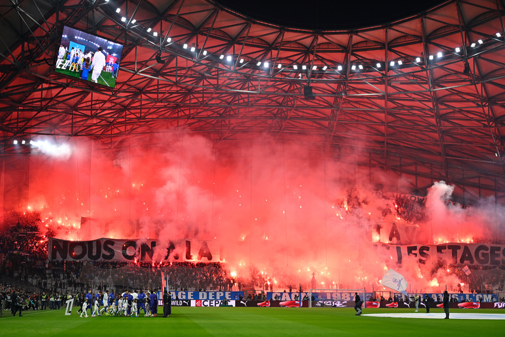 Fans light flares before the French League One soccer match between Marseille and Monaco in Marseille, France, Sunday, Dec. 14, 2025. (AP Photo/Philippe Magoni)