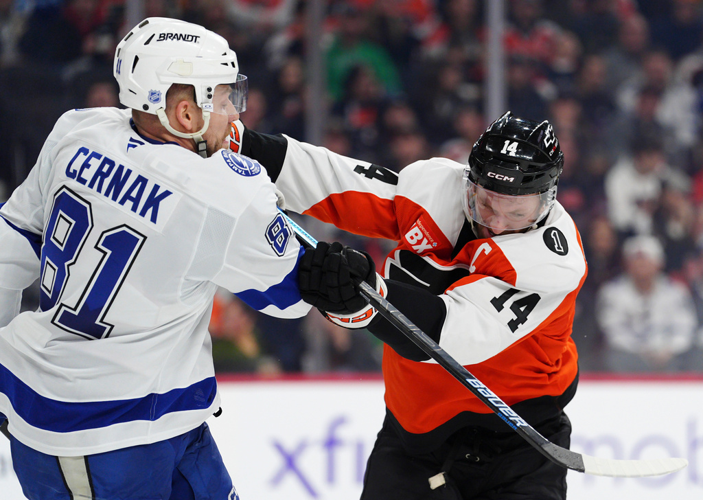 Philadelphia Flyers' Sean Couturier (14) checks Tampa Bay Lightning's Erik Cernak (81) during the second period of an NHL hockey game, Saturday, Jan. 10, 2026, in Philadelphia. (AP Photo/Derik Hamilton)