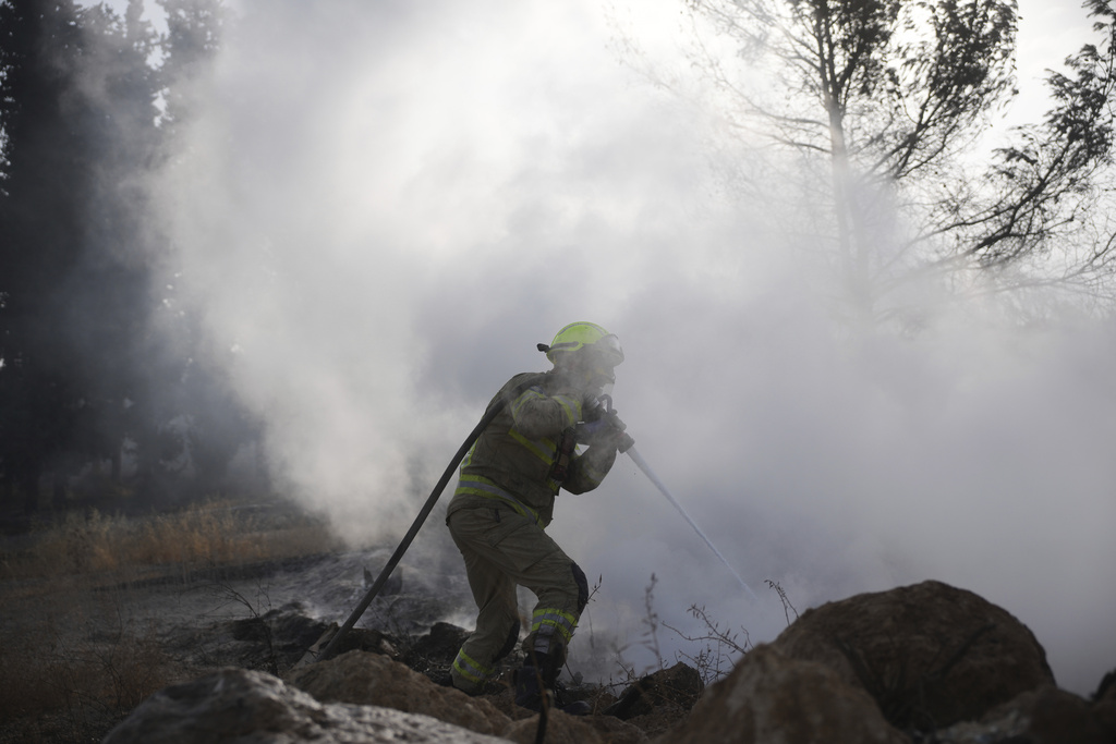 An Israeli firefighter battles a wildfire near Latrun, Israel, outside of Jerusalem, Thursday, May 1, 2025. (AP Photo/Ohad Zwigenberg)