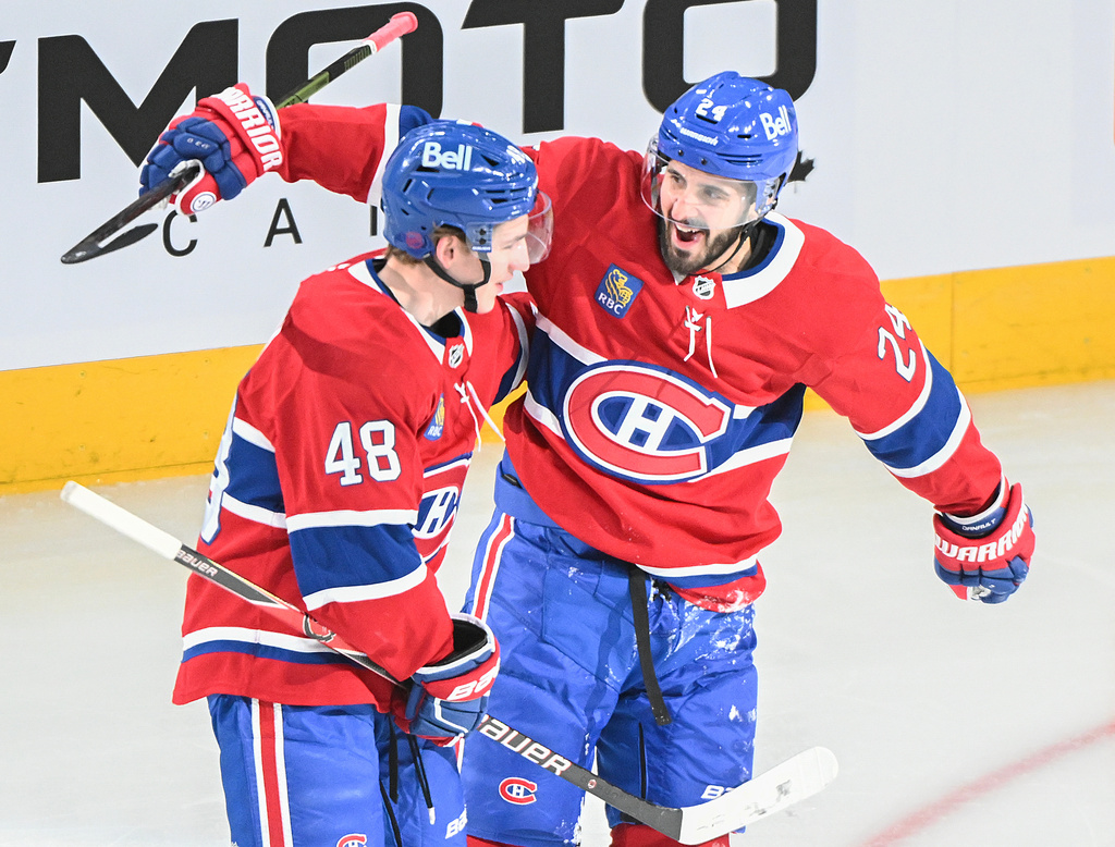 Montreal Canadiens' Lane Hutson (48) celebrates with teammate Phillip Danault (24) after scoring against the Calgary Flames during the second period of an NHL hockey game in Montreal, Wednesday, Jan. 7, 2026. (Graham Hughes/The Canadian Press via AP)