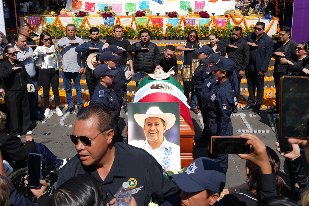 People gather to honor late Mayor Carlos Alberto Manzo Rodríguez, who was shot during Day of the Dead celebrations, in Uruapan, Michoacan state, Mexico, Sunday, Nov. 2, 2025. (AP Photo/Eduardo Verdugo)