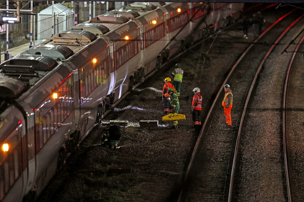 Emergency personnel inspect a train at the Huntingdon, England, train station in Cambridgeshire after people were stabbed Saturday, Nov. 1, 2025. (Chris Radburn/PA via AP)