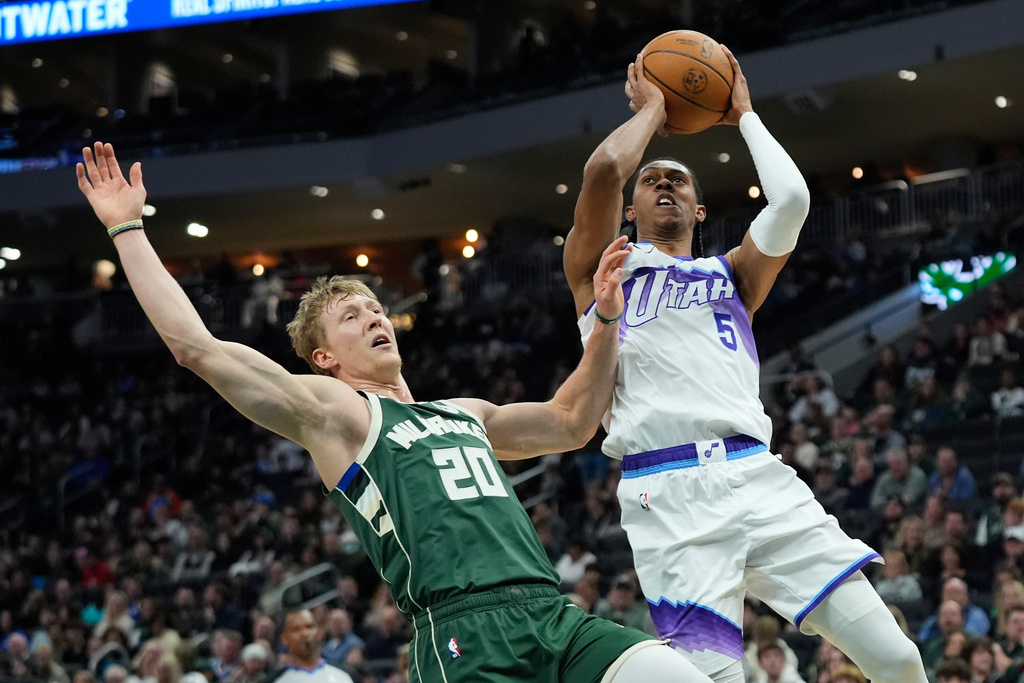 Utah Jazz's Cody Williams (5) shoots against Milwaukee Bucks' AJ Green during the first half of an NBA basketball game Saturday, March 7, 2026, in Milwaukee. (AP Photo/Aaron Gash)