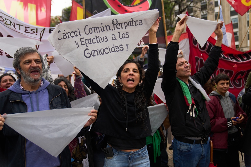 Protesters hold white headscarves during a countermarch to a demonstration organized by former servicemen accused of human rights violations during the last dictatorship, in Buenos Aires, Argentina, Saturday, Nov. 29, 2025. (AP Photo/Rodrigo Abd)