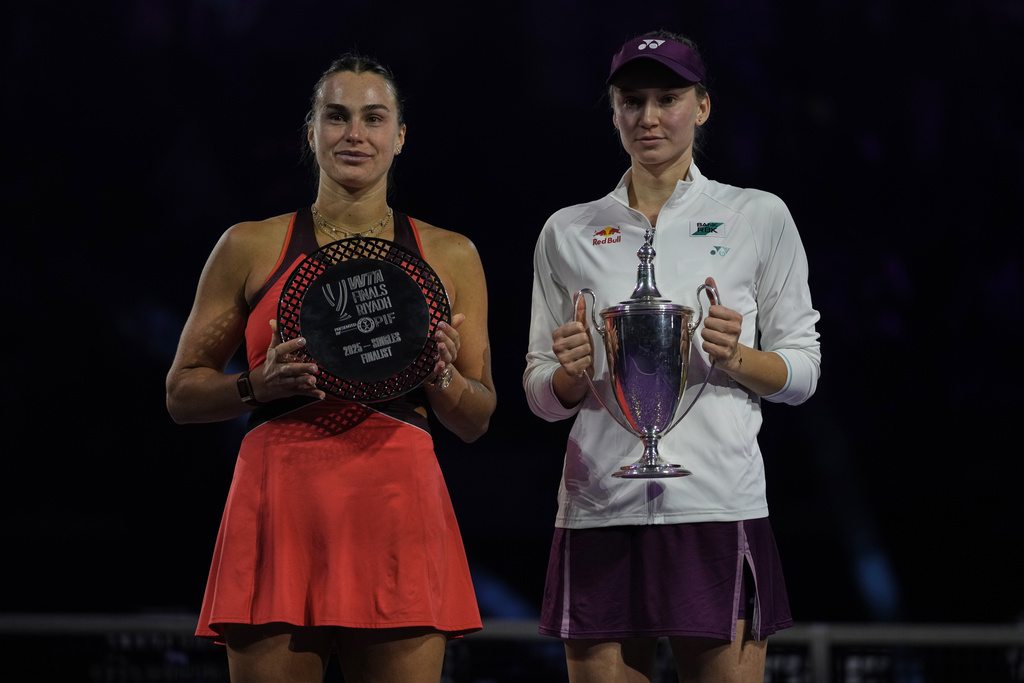 Elena Rybakina of Kazakhstan, right, holds her trophy poses with runner up Aryna Sabalenka of Belarus during the awards ceremony for the women's singles final match of the WTA finals in Riyadh, Saudi Arabia, Saturday, Nov. 8, 2025. (AP Photo/ Fatima Shbair)