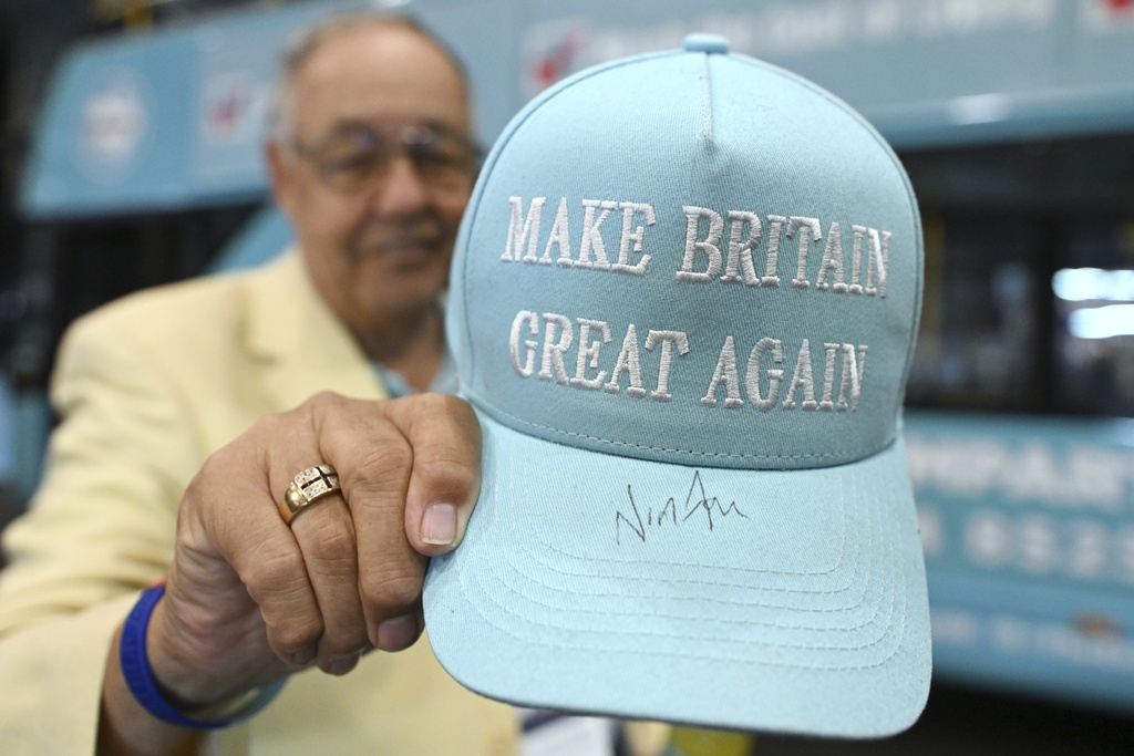 A member of the party shows his hat signed by Nigel Farage during the Reform party's annual conference at the National Exhibition Centre in Birmingham, England, Saturday, Sept. 6, 2025.(AP Photo/Thomas Krych)