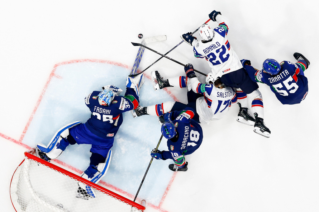 Italy's goaltender Davide Fadani, left, Nicholas Saracino, second left, and Luca Zanatta, right, challenge Norway's Eirik Salsten, center, and Martin Ronnild during the Men's Ice Hockey World Championship preliminary round match between Italy and Norway in Fribourg, Switzerland, Tuesday, May 19, 2026. (Anthony Anex/Keystone via AP)