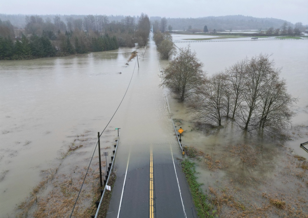 The flooding Snoqualmie River has closed NE 124th St., which connects W. Snoqualmie Valley Rd. NE on the Redmond side, and SR-203 on the Duvall and Carnation side, Wednesday, Dec. 10, 2025, near Novelty, Wash. (Ken Lambert/The Seattle Times via AP)