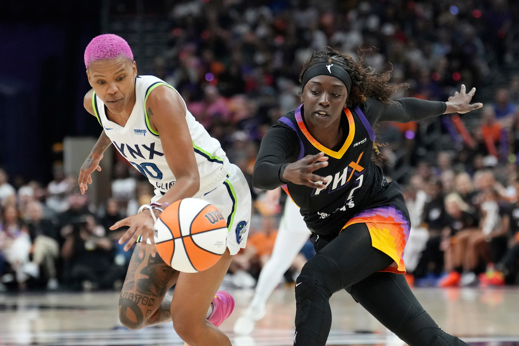 Minnesota Lynx guard Courtney Williams, left, battles with Phoenix Mercury guard Kahleah Copper for a loose ball during the first half of Game 3 of a WNBA basketball playoff semifinals series game Friday, Sept. 26, 2025, in Phoenix. (AP Photo/Ross D. Franklin)