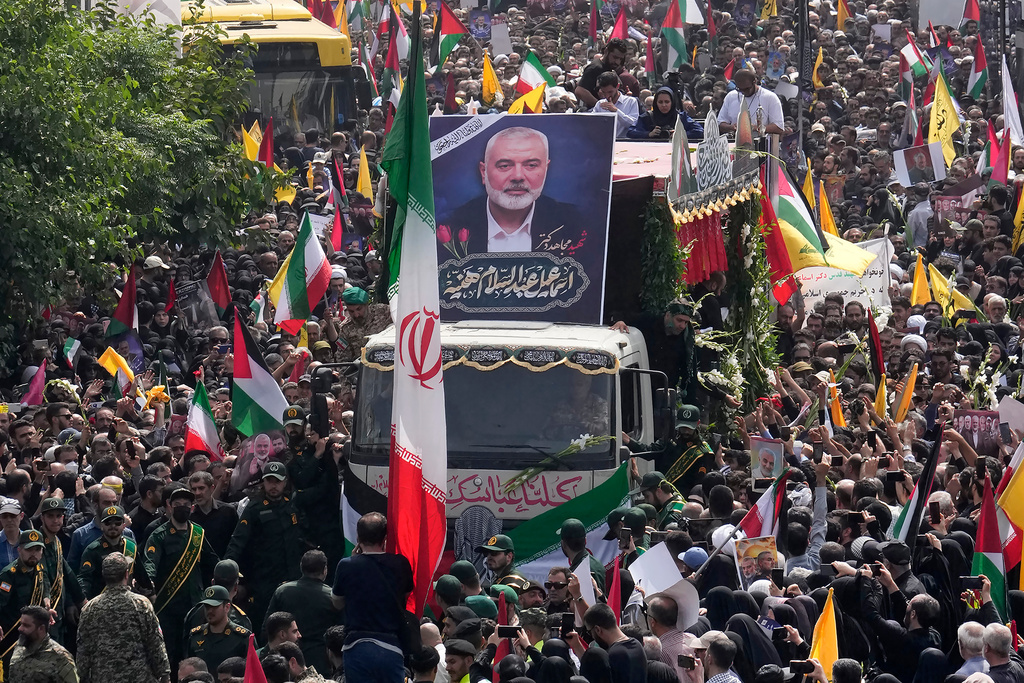 FILE - Iranians follow a truck, center, carrying the coffins of Hamas leader Ismail Haniyeh and his bodyguard who were killed in an assassination blamed on Israel, during their funeral ceremony at Enqelab-e-Eslami (Islamic Revolution) Sq. in Tehran, Iran, Aug. 1, 2024. (AP Photo/Vahid Salemi, File)