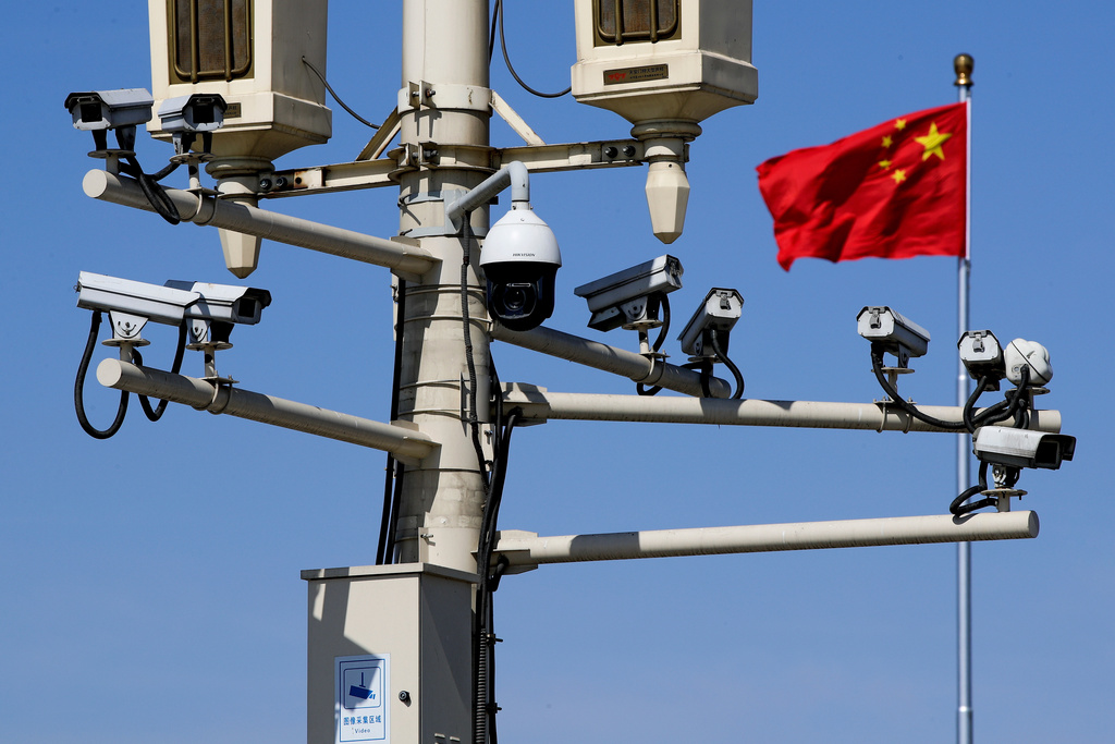 FILE - A Chinese national flag flutters near surveillance cameras mounted on a lamp post in Tiananmen Square in Beijing, Friday, March 15, 2019. (AP Photo/Andy Wong, File)