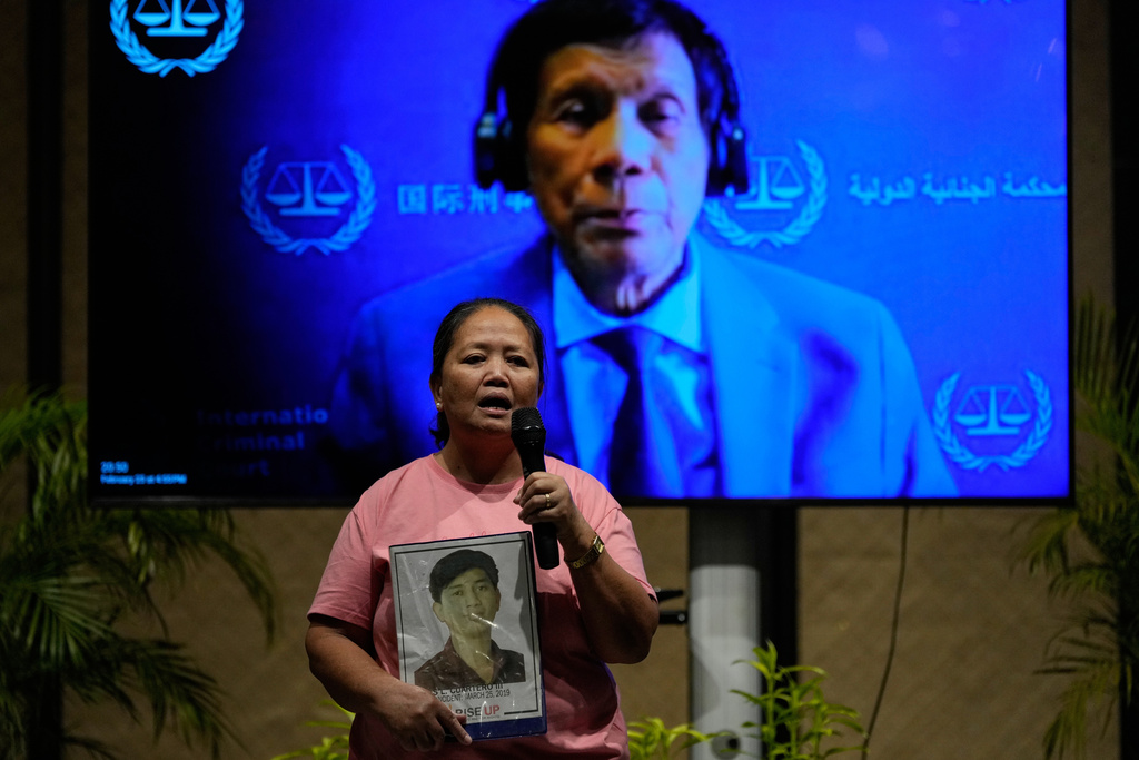A photo of Philippine President Rodrigo Duterte is seen on the screen as a mother of a victim on the deadly anti-drugs crackdowns of Duterte's administration speaks before watching a live stream of pre-trial hearings from The Hague, at a venue in Quezon City, Philippines on Monday, Feb. 23, 2026.(AP Photo/Aaron Favila)