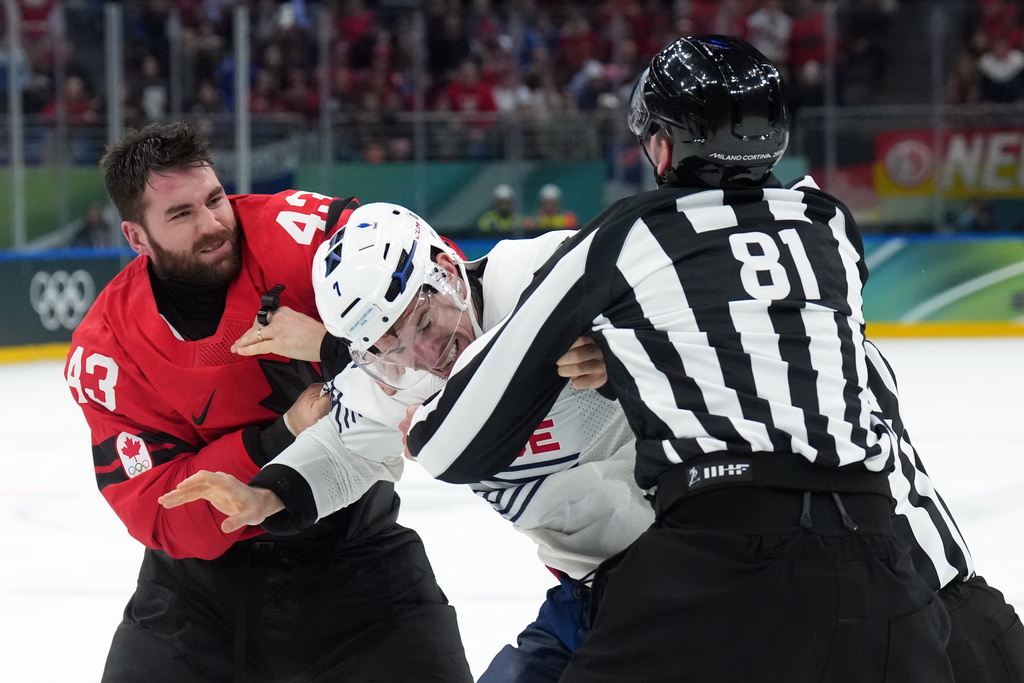 Canada's Tom Wilson (43) and France's Pierre Crinon, center, fight in the third period during a preliminary round game of men's ice hockey between Canada and France at the 2026 Winter Olympics, in Milan, Italy, Sunday, Feb. 15, 2026. (Nathan Denette/The Canadian Press via AP)