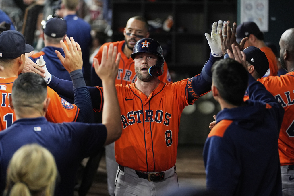 Houston Astros' Christian Walker celebrates with the team after hitting a solo home run in the third inning of a baseball game against the Texas Rangers Saturday, Sept. 6, 2025, in Arlington, Texas. (AP Photo/Tony Gutierrez)