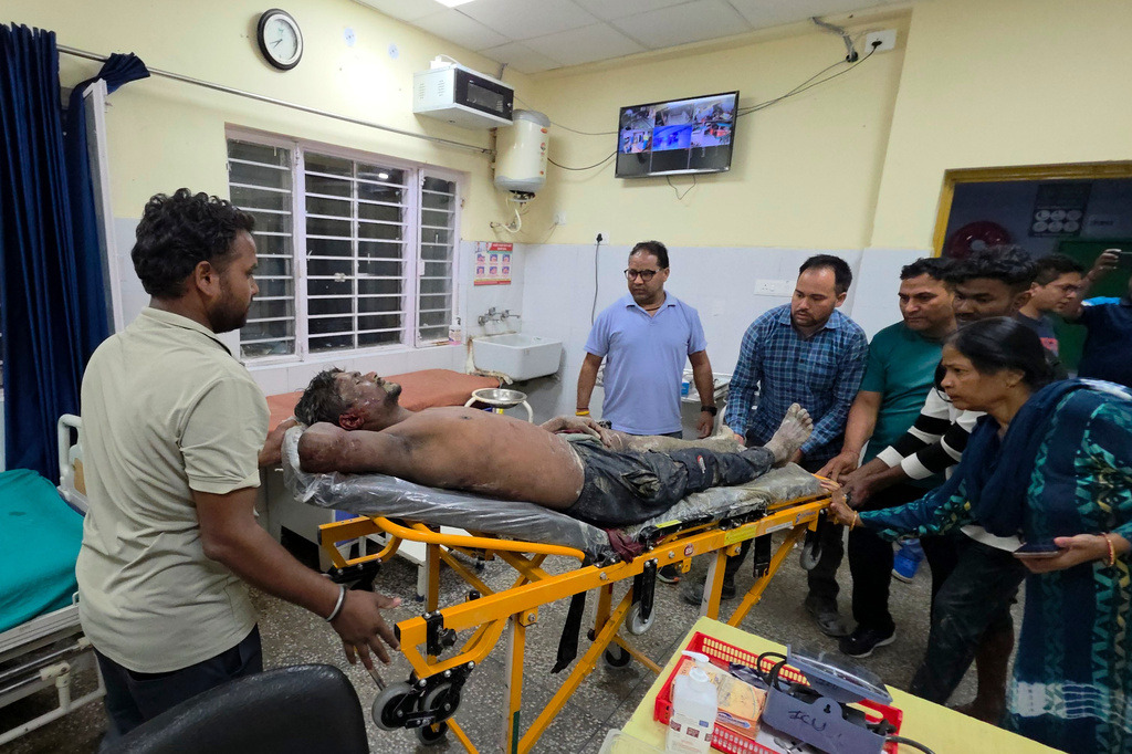 An injured person is moved for treatment at a hospital after the collapse of an under-construction tunnel at a hydropower project in Chamoli district of Uttarakhand, India, Thursday, Aug. 13, 2026. (AP Photo/Surendra Rawat)