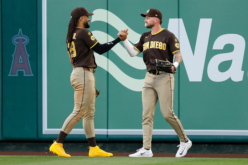 San Diego Padres center fielder Jackson Merrill (3) is greeted by San Diego Padres right fielder Fernando Tatis Jr. (23) after catching a ball hit by Los Angeles Angels' Yoan Moncada (10) during the second inning of a baseball game Saturday, April 18, 2026, in Anaheim, Calif. (AP Photo/Caroline Brehman)