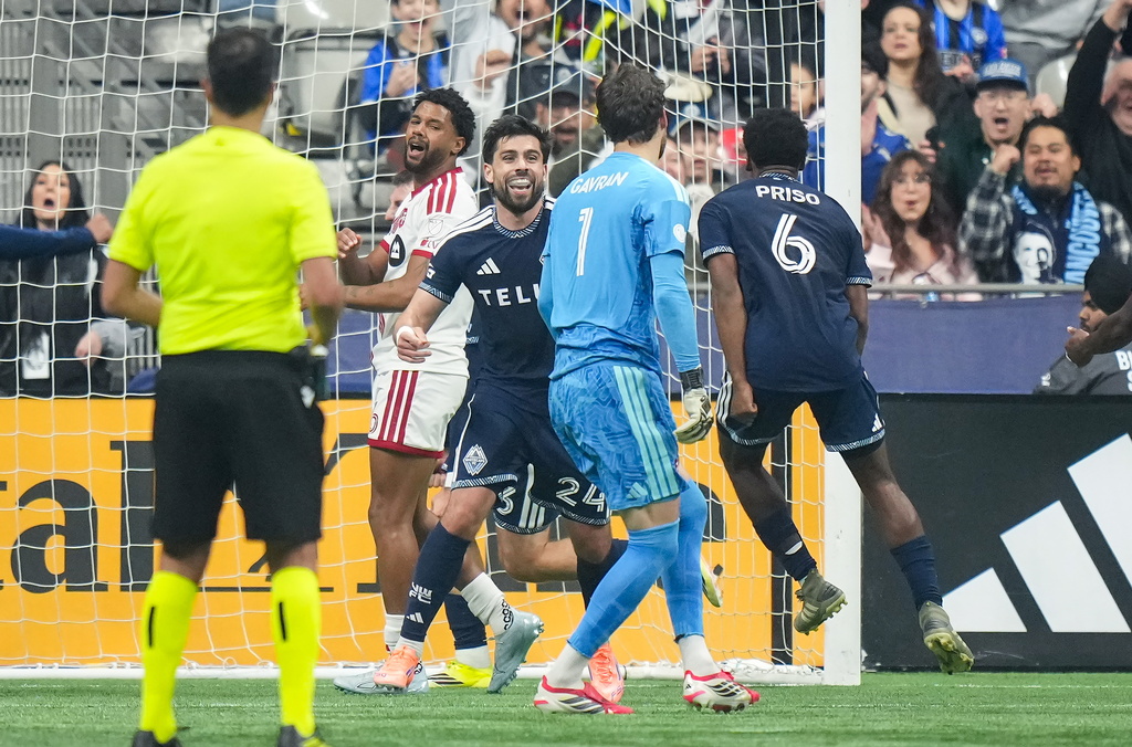 Vancouver Whitecaps' Brian White (24) and Ralph Priso (6) celebrate White's goal against Toronto FC goalkeeper Luka Gavran (1) during the first half of an MLS soccer match, in Vancouver, on Saturday, Feb. 28, 2026. (Darryl Dyck/The Canadian Press via AP)