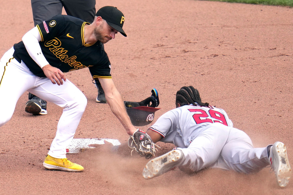 Washington Nationals' James Wood (29) slides past the late tag by Pittsburgh Pirates second baseman Brandon Lowe with a stolen base during the tenth inning of a baseball game in Pittsburgh, Thursday, April 16, 2026. (AP Photo/Gene J. Puskar)