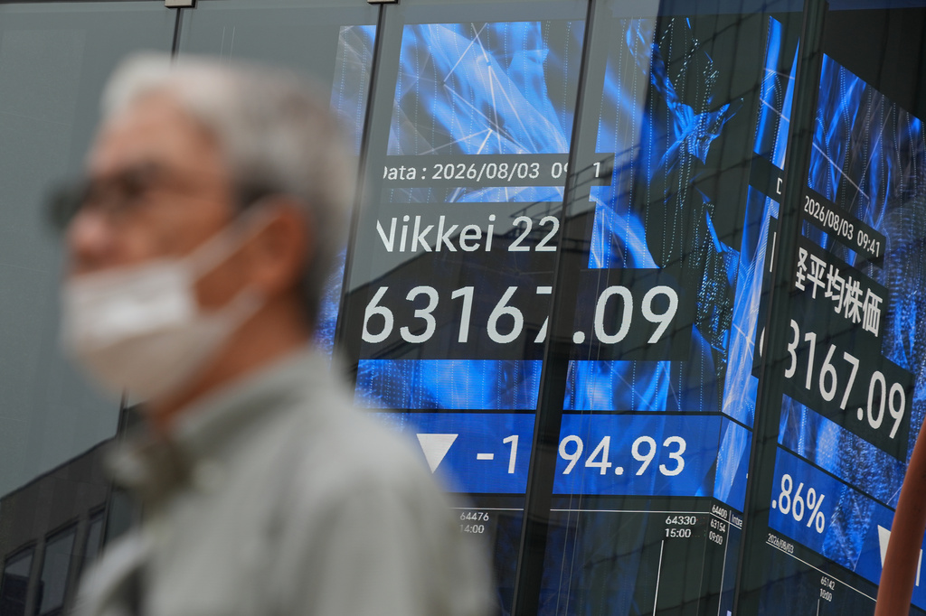 A person walks past an electronic board showing Japan's Nikkei index at a securities firm in Tokyo on Monday, Aug. 3, 2026. (AP Photo/Eugene Hoshiko)