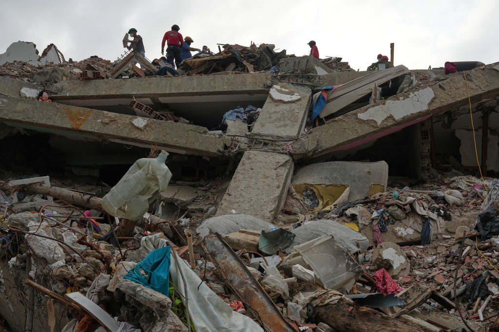 FILE - Workers clear rubble from an O-P-P housing tower that was built as part of a government program, after it collapsed during twin earthquakes in La Guaira, Venezuela, July 22, 2026. (AP Photo/Ariana Cubillos, File)
