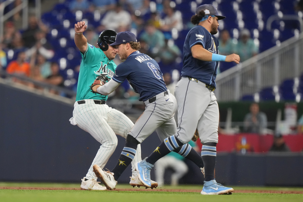 Tampa Bay Rays shortstop Taylor Walls (6) tags Miami Marlins' Jakob Marsee as he is caught between first and second base during the second inning of a baseball game Sunday, June 7, 2026, in Miami. (AP Photo/Marta Lavandier)