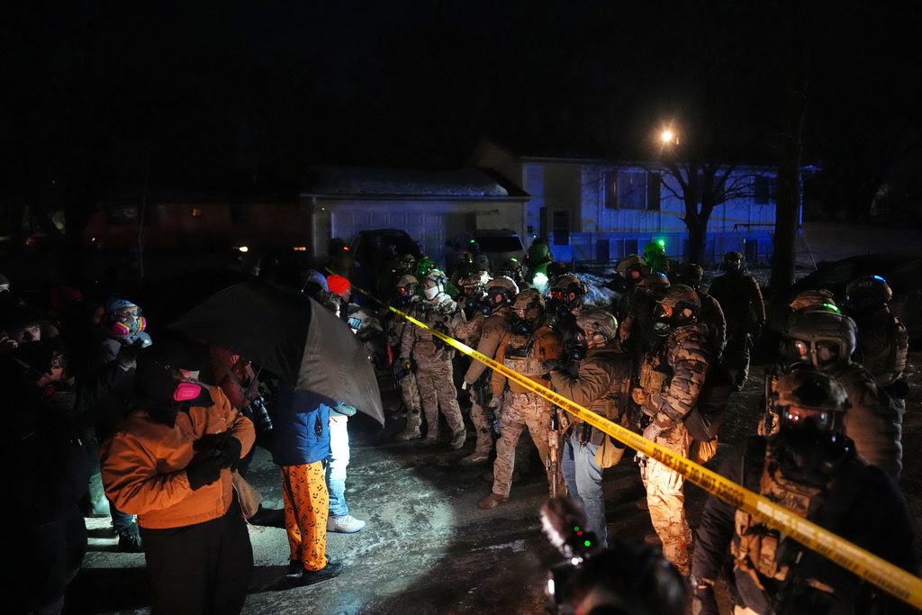 Law enforcement officers at the scene of a reported shooting Wednesday, Jan. 14, 2026, in Minneapolis. (AP Photo/Adam Gray)