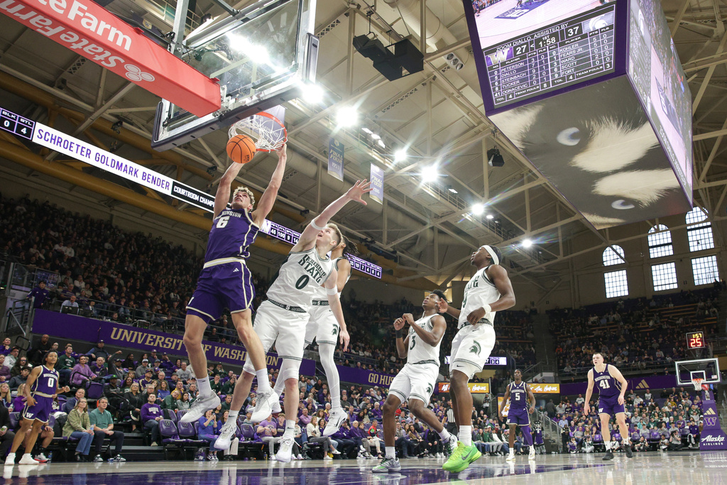 Washington forward Hannes Steinbach (6) dunks the ball as Michigan State forward Jaxon Kohler (0) defends during the first half of an NCAA college basketball game, Saturday, Jan. 17, 2026, in Seattle. (AP Photo/Jason Redmond)
