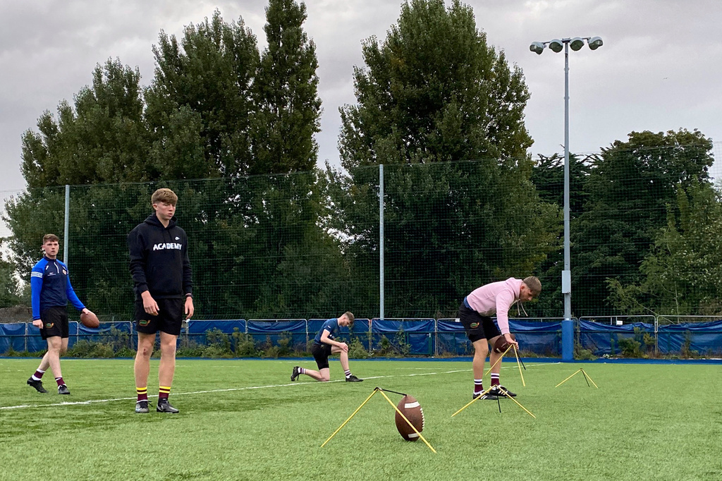 FILE - Irish kicker Andy Quinn, second left, lines himself up for a field-goal attempt in warmups before a "kicking king" competition at Donnybrook Stadium in Dublin, Ireland, on Friday, Aug. 25, 2023. (AP Photo/Kenneth Maguire, File)