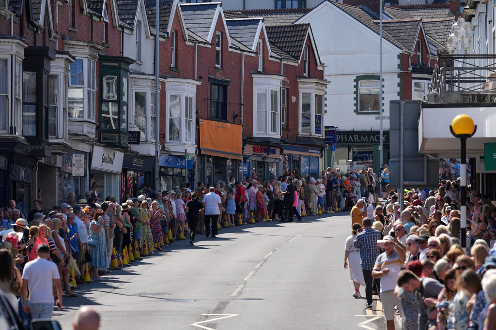 Fans of singer Bonnie Tyler line the streets of Mumbles as they await her coffin to be transported back to her former home ahead of the funeral in Mumbles, Wales, Saturday, Aug. 15, 2026. The Total Eclipse Of The Heart musician, whose real name was Gaynor Hopkins, died in hospital in Portugal on July 8 at the age of 75. (AP Photo/Alastair Grant)