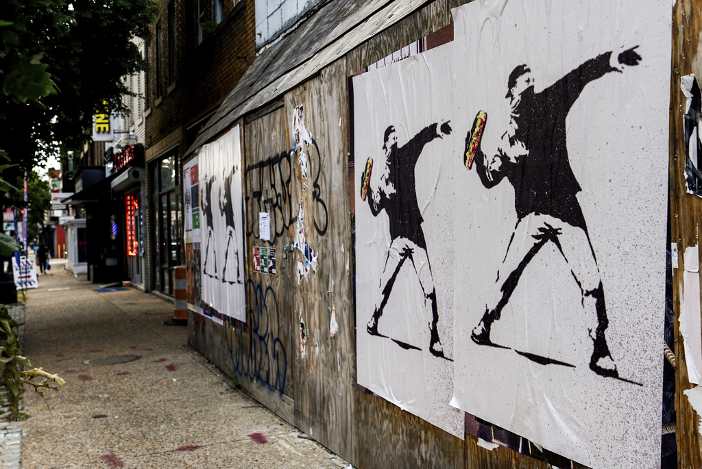 Posters of a person throwing a sandwich are pictured along H Street, Sunday, Aug. 17, 2025, in Washington. (AP Photo/Julia Demaree Nikhinson)